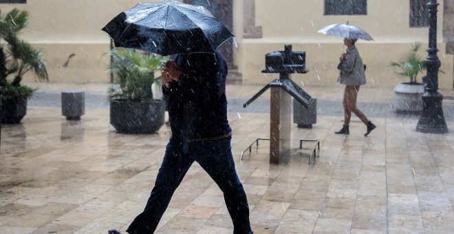 Una persona se protege de la lluvia con un paraguas, esta mañana en València./EFE