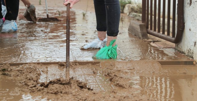 Una mujer limpia la entrada de una casa después de las inundaciones causadas por las lluvias torrenciales en San Javier, Murcia. REUTERS / Sergio Perez