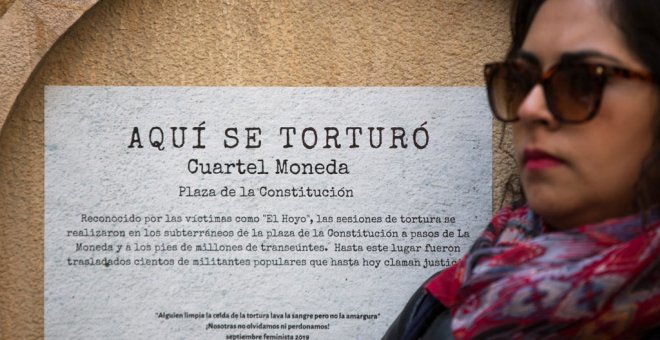 Una mujer se manifiesta este 10 de septiembre frente a un cartel que conmemora uno de los centros de tortura de la dictadura de Augusto Pinochet en Santiago de Chile Alberto Valdés / EFE