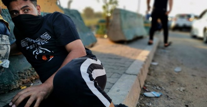 Un manifestante se refugia durante una de las protestas contra el Gobierno iraquí. (REUTERS/Thaier Al-Sudani)