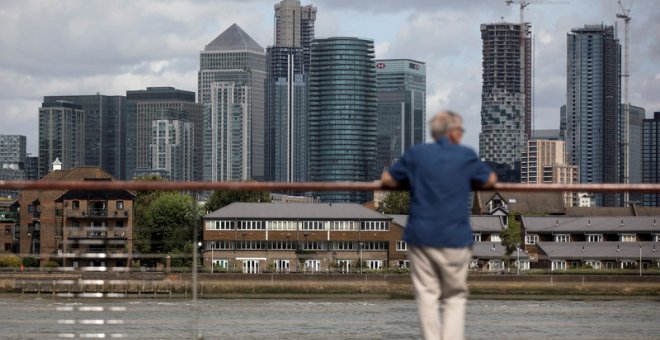Un hombre mira hacia el distrito financiero de Canary Wharf en Londres. REUTERS/Simon Dawson