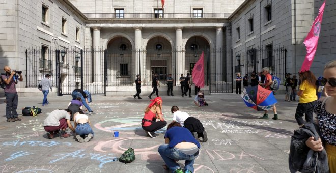 Algunos activistas han pintado con tiza mensajes reivindicativos frente a la entrada del Ministerio para la Transición Ecológica. | Foto: G. M. M.