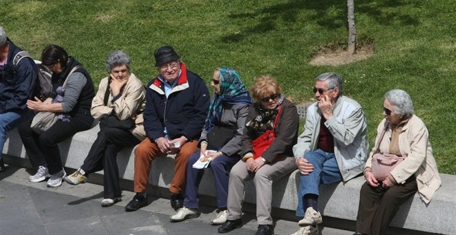 Varios pensionistas sentados al sol. E.P.