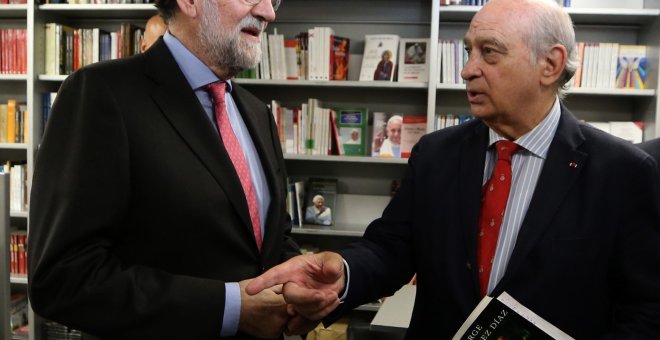 10/10/2019.- El expresidente del Gobierno Mariano Rajoy (i) conversa con el exministro del Interior Jorge Fernández Díaz (d) durante la presentación de su libro "Cada día tiene su afán". / EFE - JAVIER LIZÓN