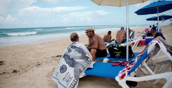 Un turista usa una toalla con el diseño de un billete de 100 dólares en la playa de Santa María en las afueras de La Habana (Cuba). REUTERS / Alexandre Meneghini