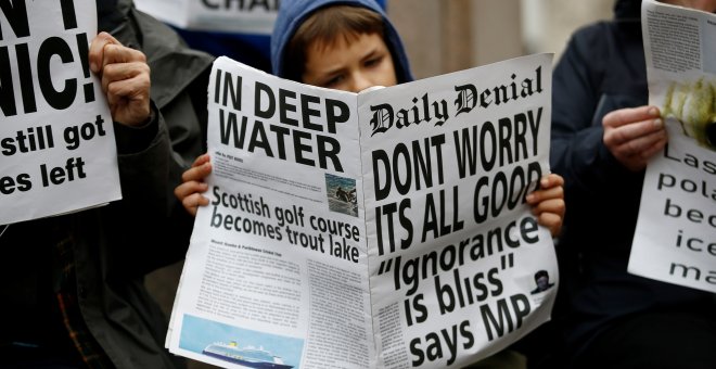Un manifestante lee un periódico falso con el titular: "No se preocupe, todo va bien. Ignorancia es felicidad". REUTERS/Henry Nicholls