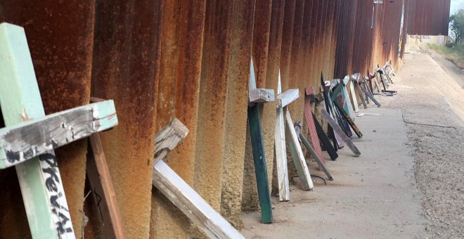 Apoyadas sobre el muro fronterizo en Nogales (México) hay decenas de cruces de madera en honor a los migrantes que perecieron tratando de alcanzar EE.UU. con vida. / Aitana Vargas