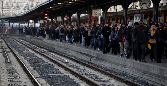 Los viajeros caminan en una plataforma en la estación de tren Gare de l'Est durante una huelga de todos los sindicatos de trabajadores franceses de SNCF y la red de transporte de París (RATP) en París como parte de un segundo día de huelga nacional y prot