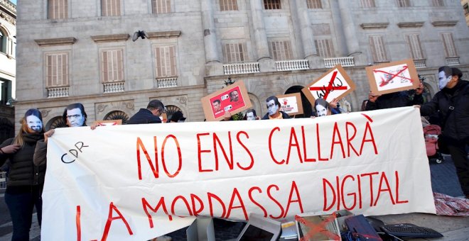 Varias personas sostienen una pancarta en la que se puede leer 'No nos callará la mordaza digital' durante una manifestación convocada por los CDR en protesta contra la Ley mordaza frente al ayuntamiento de Barcelona este sábado. EFE/Alejandro García