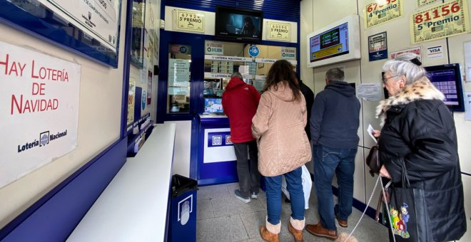 Varias personas compran décimos de Lotería de Navidad en una Administración del centro de Madrid. E.P./Eduardo Parra