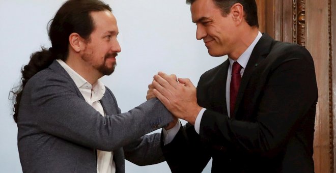 30/12/2019.- El  candidato a la investidura, Pedro Sánchez (d), y el líder de Podemos, Pablo Iglesias (i), estrechan sus manos tras el acto de firma del acuerdo programático. / EFE - JUANJO MARTÍN