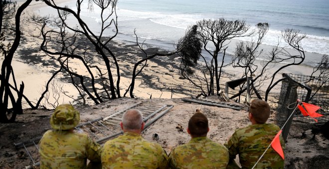 Soldados observan una playa calcinada de Victoria. REUTERS