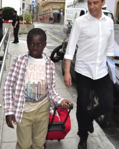 El pequeño Adou, conocido como 'niño de la maleta', junto a un funcionario del Area de Menores, momentos antes de encotrarse con su madre. EFE/Reduan