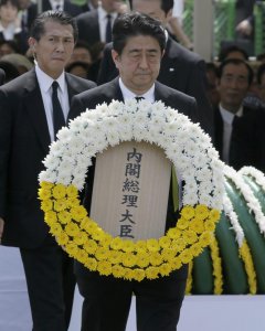 El primer ministro japonés Shinzo Abe lleva una corona de flores en el acto de recuerdo a las víctimas de la bomba atómica sobre Nagasaki, en el 70 aniversario del bombardeo sobre la ciudad japonesa.. EFE/EPA/KIMIMASA MAYAMA