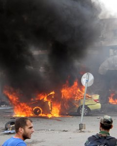 Un soldado del ejército sirio y varios civiles inspeccionan el daño tras las explosiones que golpearon la ciudad siria de Tartus. REUTERS