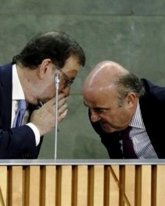 Mariano Rajoy hablándole al oído al ministro de Economía, Luis de Guindos, en la presentación del libro de este/EFE