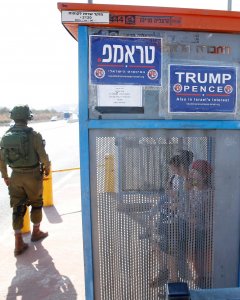 Soldados israelíes al lado de una parada de autobús con carteles de la rama israelí del Partido Republicano de EEUU a favor de Donald Trump, cerca del asentamiento judío de Ariel en Cisjordania. REUTERS / Baz Ratner