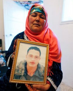Nour Al Houda (65), madre de Anis Amri, el tunecino de 24 años cuyos documentos se hallaron en la cabina del camión que mató a doce personas en un mercadillo navideño de Berlín, posa con un retrato de su hijo en su vivienda en Oueslatia (Túnez) hoy, 22 de