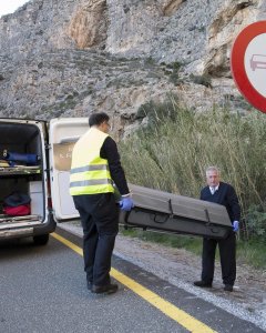Miembros de los servicios funerarios trasladan los restos mortales de la joven que ha fallecido tras caer desde una altura considerable, cuando estaba haciendo escalada en el paraje conocido como Tajo de los Vados, en Vélez Benaudalla (Granada). EFE/PAQUE