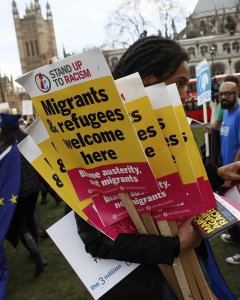 Un manifestante sujeta varias pancartas durante la manifestación en defensa de los inmigrantes en Londres. - REUTERS