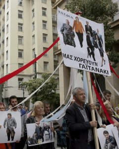 Varios activistas muestran una pancarta que reza 'Nuestro baile de mayo' mientras participan en una manifestación durante la huelga general de 24 horas. EFE/Alexandros Vlachos
