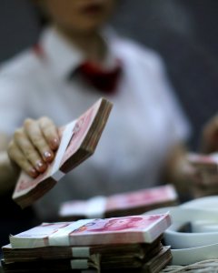 Empleada manejando yuanes. REUTERS