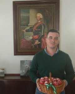 El alcalde de Cañada Real, Rodrigo Rodríguez Hans, posa bajo el retrato de Carlos III y con una cesta de huevos de Pascua.