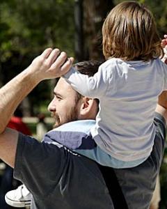 Un padre pasea con su hijo a hombros - EFE