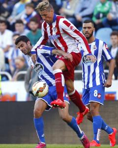 El jugado del Deportivo Juan Dominguez disputa un balón con el delantero del Atletico Fernando Torres. REUTERS/Miguel Vidal