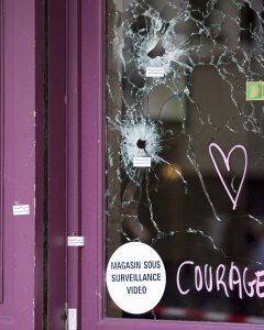 Un corazón y la palabra 'coraje' junto a los impactos de bala en uno de los cristale del restaurante Casa Nostra en la Rue de la Fountaine au Roi de París.- EFE