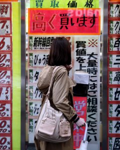 Una mujer mira a lista de precios de una tienda descuento en el barrio comercial de Tokio. REUTERS/Yuya Shino