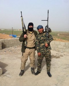 Soria posando armado con un soldado peshmerga.