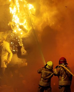 Dos bomberos trabajan durante la tradicional cita con el ritual del fuego fallero de San José. /EFE