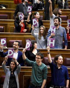 Los diputados de Podemos sacan unos carteles en favor de los derechos humanos esta tarde durante el pleno del Congreso de los Diputados. EFE/Fernando Villar