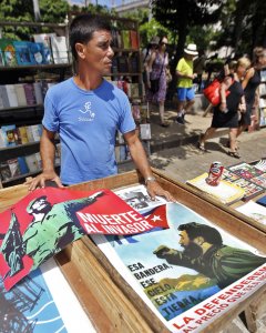Un hombre expone varios carteles del líder de la revolución cubana Fidel Castro, con motivo de su 90 cumpleaños. EFE/Ernesto Mastrascusa