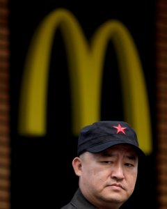 Un hombre usando una gorra con la estrella roja en el exterior de un restaurante de McDonald's en la comercial calle de Wangfujing en Pekín. REUTERS/Soo Hoo Zheyang