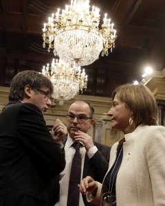 El presidente de la Generalitat, Carles Puigdemont, conversa con la presidenta del Parlament, Carme Forcadell, y el portavoz de JxS, Jordi Turull (c), poco antes del comienzo del pleno del Parlament. EFE/Alberto Estévez