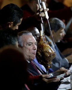 El presidente de Brasil Michel Temer comiendo carne con importantes empresarios. REUTERS/Ueslei Marcelino
