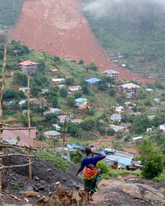 Una madre carga a su hijo en la ladera opuesta a la montaña donde se produjo la avalancha de barro de Sierra Leona. Murieron casi 400 personas, entre ellas 109 niños. REUTERS/Afolabi Sotunde