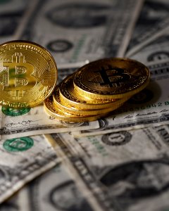 Modelos de la moneda virtual bitcoin junto a billetes de dólar. REUTERS/Dado Ruvic