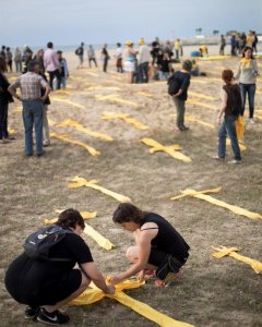 Convocatòria de plantada de creus grogues a la platja de Mataró, substituida per un desplegament de tovalloles i peces de roba grogues sobre la sorra en forma de creu . EFE/ Marta Perez
