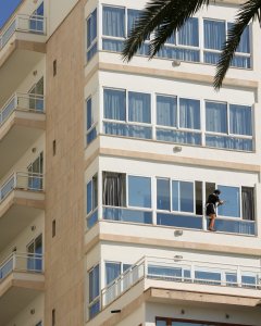 Una camarera de planta limpia los cristales de una habitación de un A hotel en Palma de Mallorca. REUTERS/Enrique Calvo