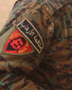 Miliciano de las YPG, en Raqqa, con la foto de Apo en el emblema. Foto: Ferran Barber