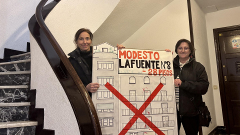 Margo y Carmen, con una pancarta, en el portal del edificio. Margo y Carmen, con una pancarta, en el portal del edificio.