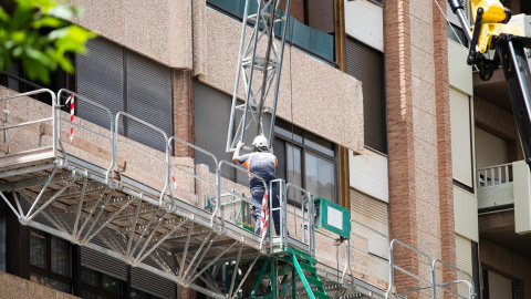 Foto de archivo de un trabajador de la construcción en un andamio.