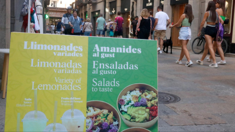 Un cartell d'un establiment a Girona que anuncia els seus productes en català, castellà i anglès. Un cartell d'un establiment a Girona que anuncia els seus productes en català, castellà i anglès.
