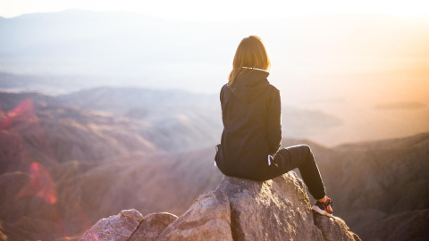 Una mujer en lo alto de una montaña.