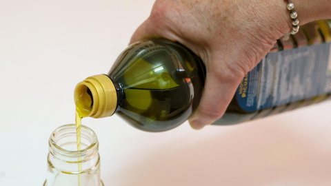 Foto de Archivo - Una persona llena un bote de aceite, a 21 de junio de 2024, en Madrid.