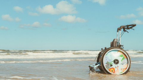 Imagen de archivo de una silla de ruedas en una playa.