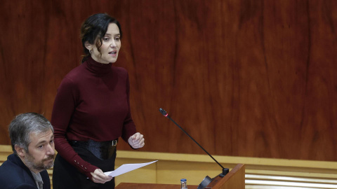 La presidenta de la Comunidad de Madrid, Isabel Díaz Ayuso (d) interviene en el pleno de la Asamblea de Madrid, este jueves.